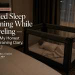 Sleep training while traveling with a baby sleeping in a travel crib in a dark hotel room.